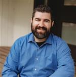 Photo of Trustee Avgeris wearing a blue button up shirt 